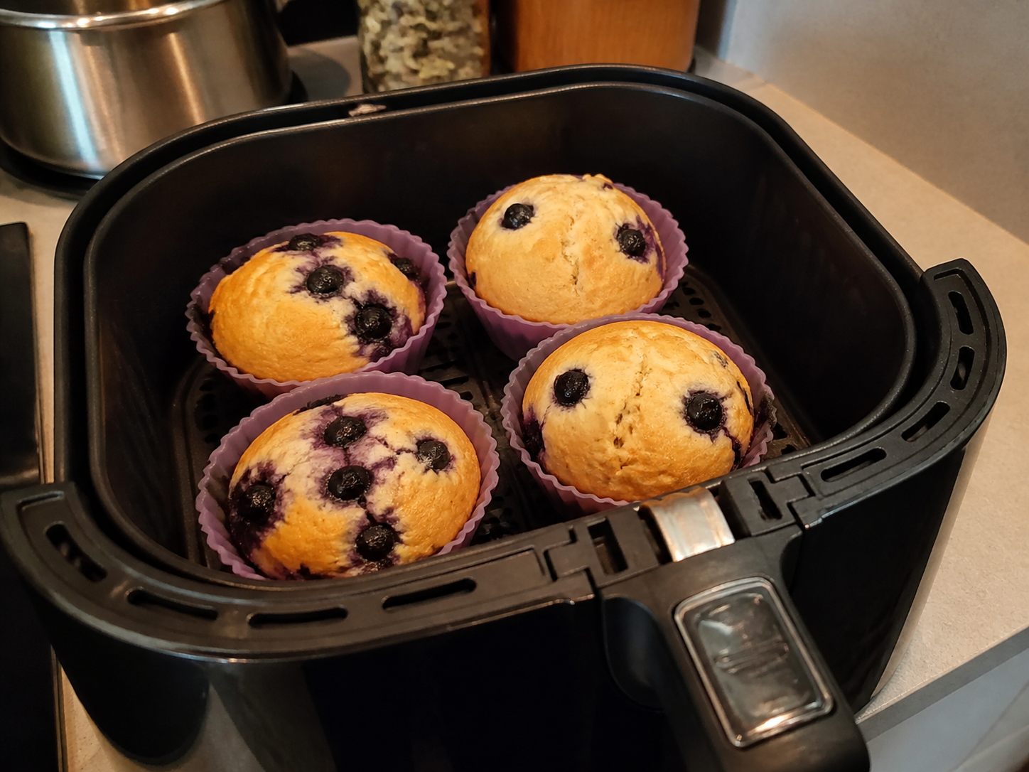Homemade blueberry muffins baking in silicone cups in an air fryer