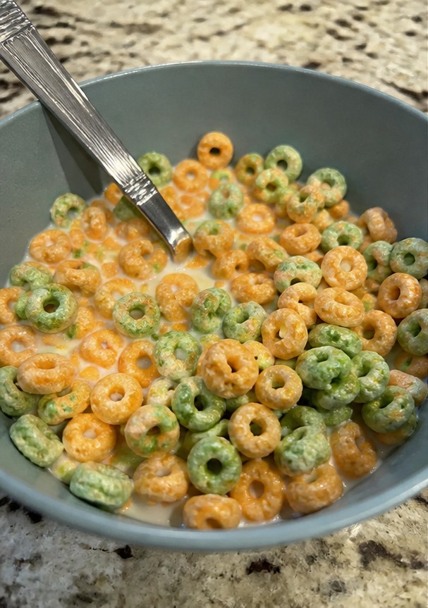 A simple bowl of golden cereal with milk on a wooden breakfast table