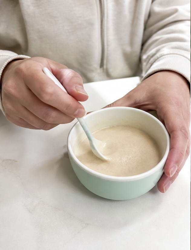 A simple bowl of golden cereal with milk on a wooden breakfast table