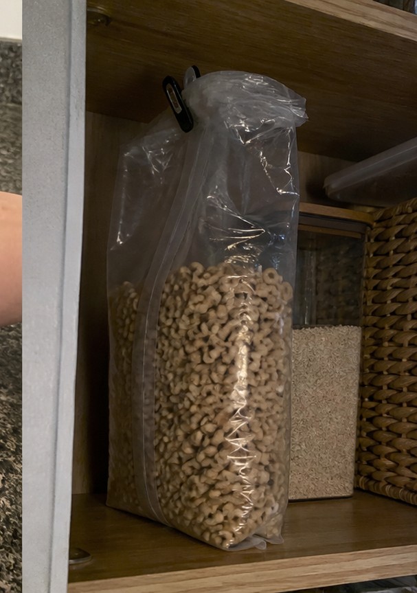 A homemade cereal snack mix with dried fruit and seeds on a parchment-lined tray