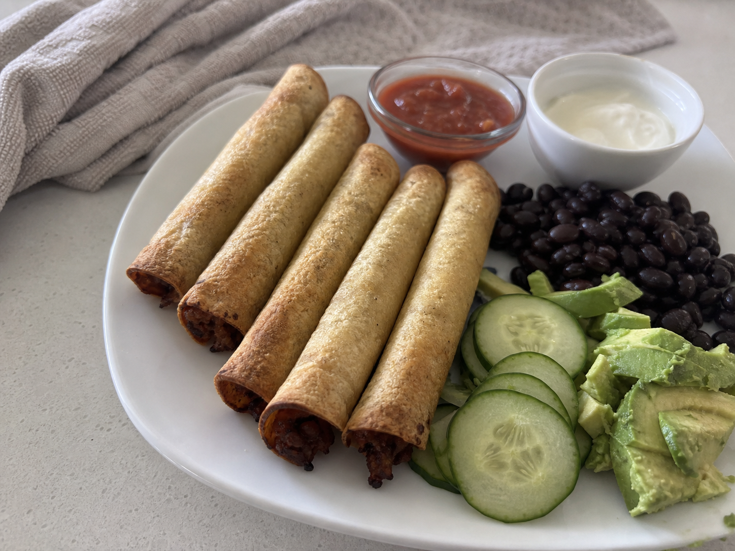 Crisp taquitos served with avocado, black beans, cucumber and two dipping sauces