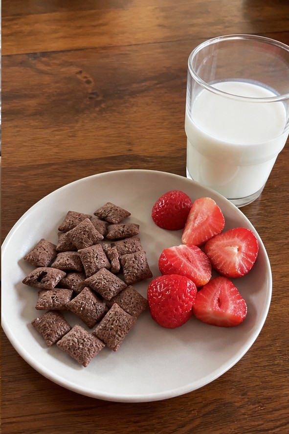 A homemade cereal snack mix with dried fruit and seeds on a parchment-lined tray