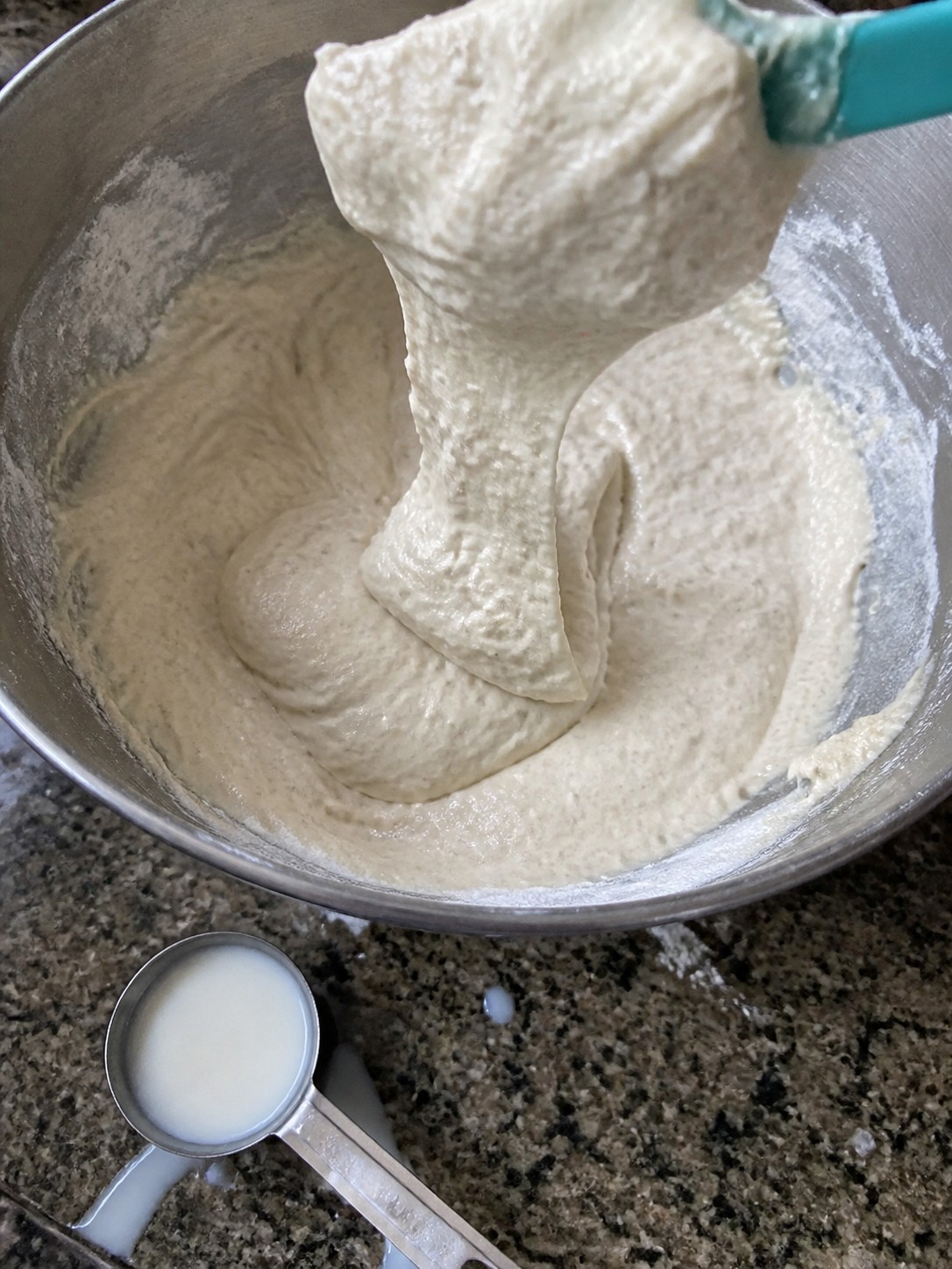 Thick muffin batter falling in a heavy ribbon from a spatula