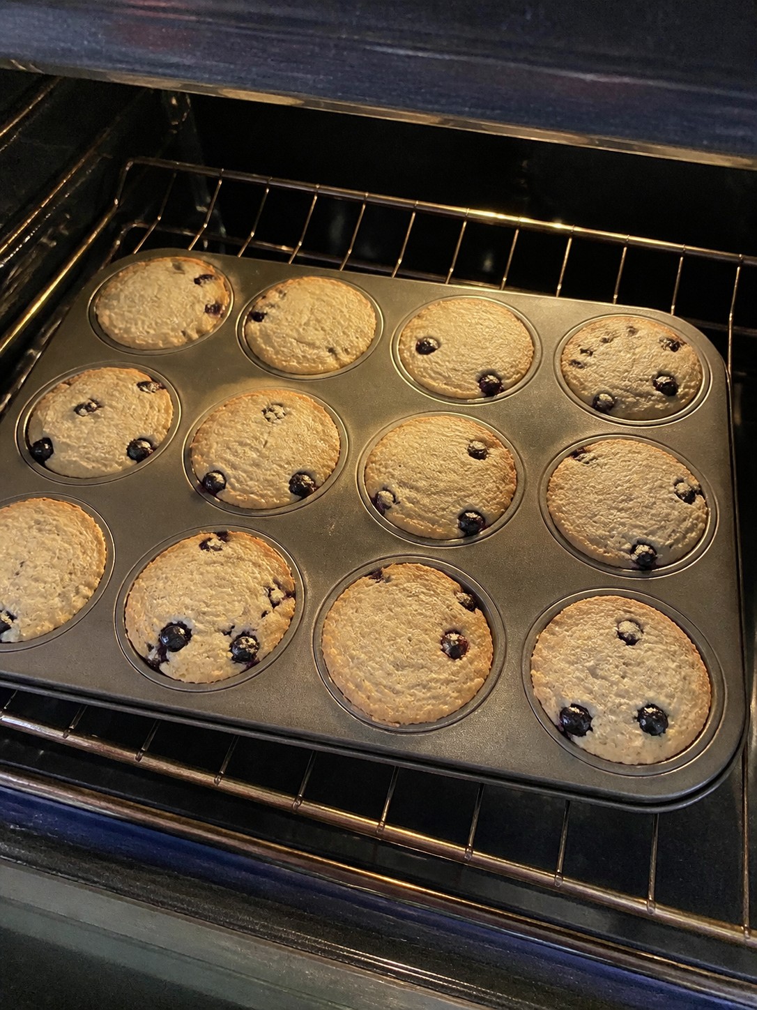 Flat wide blueberry muffins in a standard muffin pan