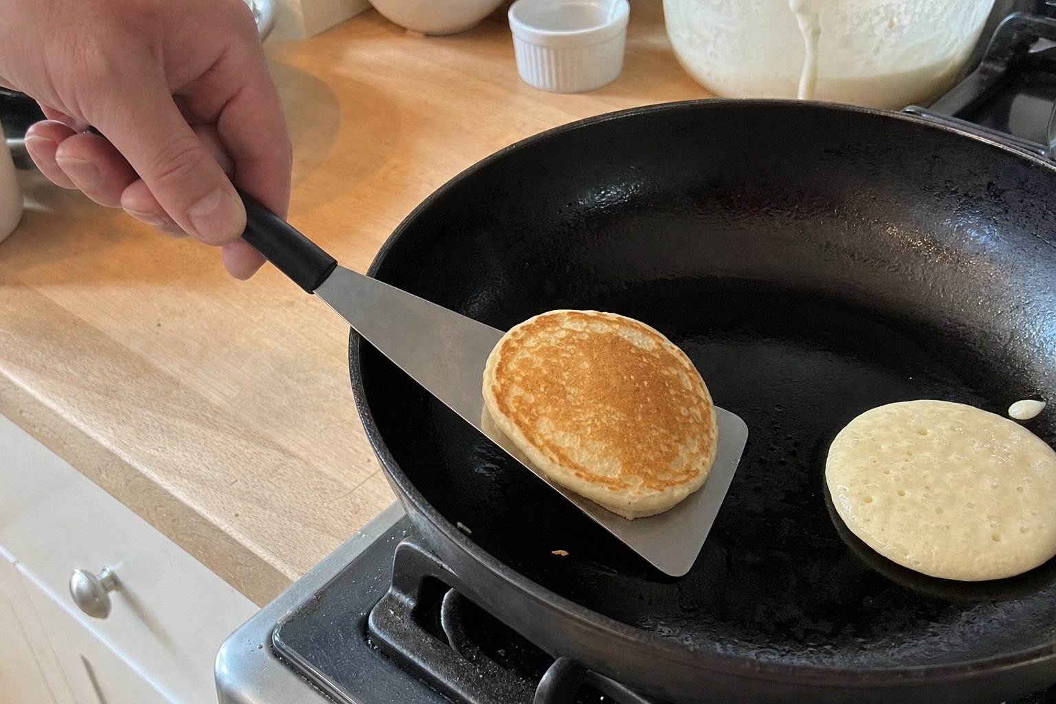 Pancakes cooking in a frying pan on a home stove