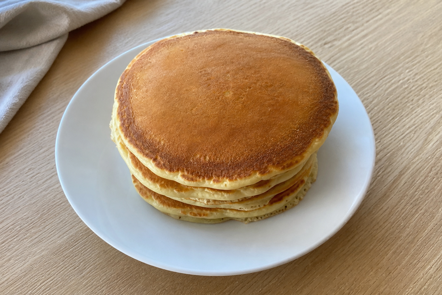 Stack of homemade pancakes on a white plate