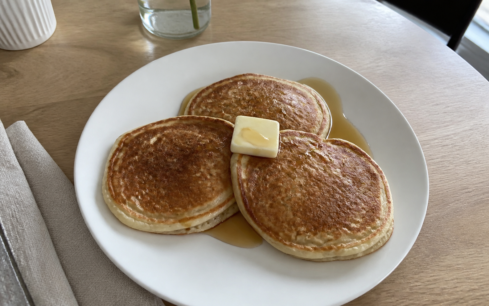 Golden homemade pancakes with berries and maple syrup