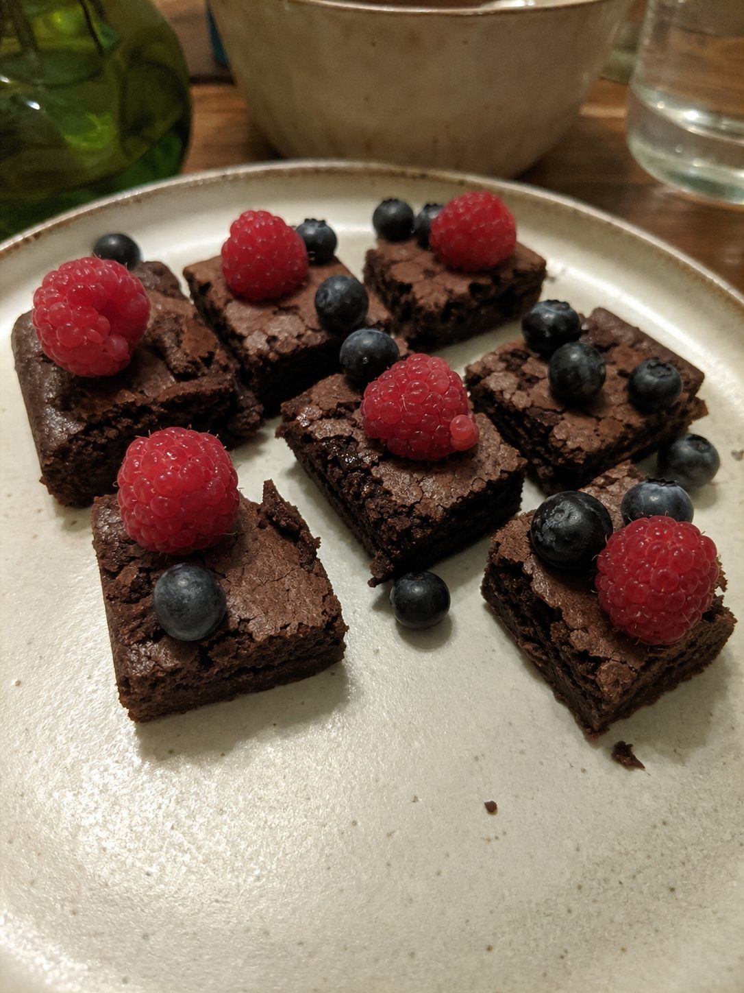 Small brownie and fruit dessert bites on a shared home party plate