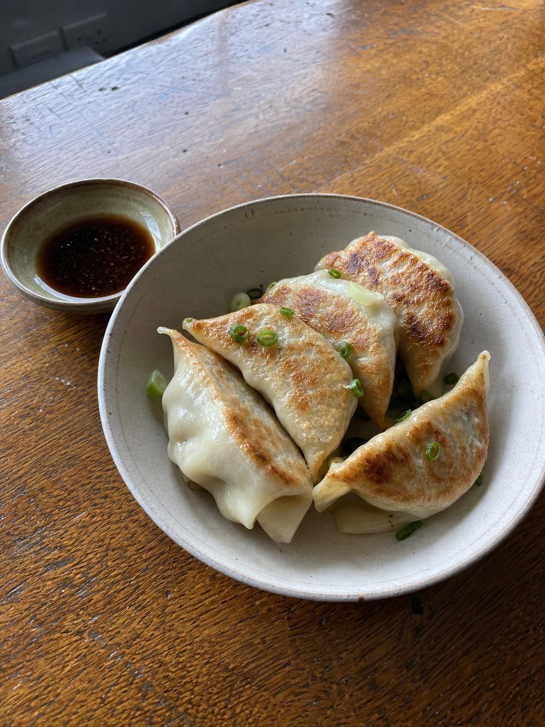 Potstickers with a soy vinegar dipping sauce on a casual table