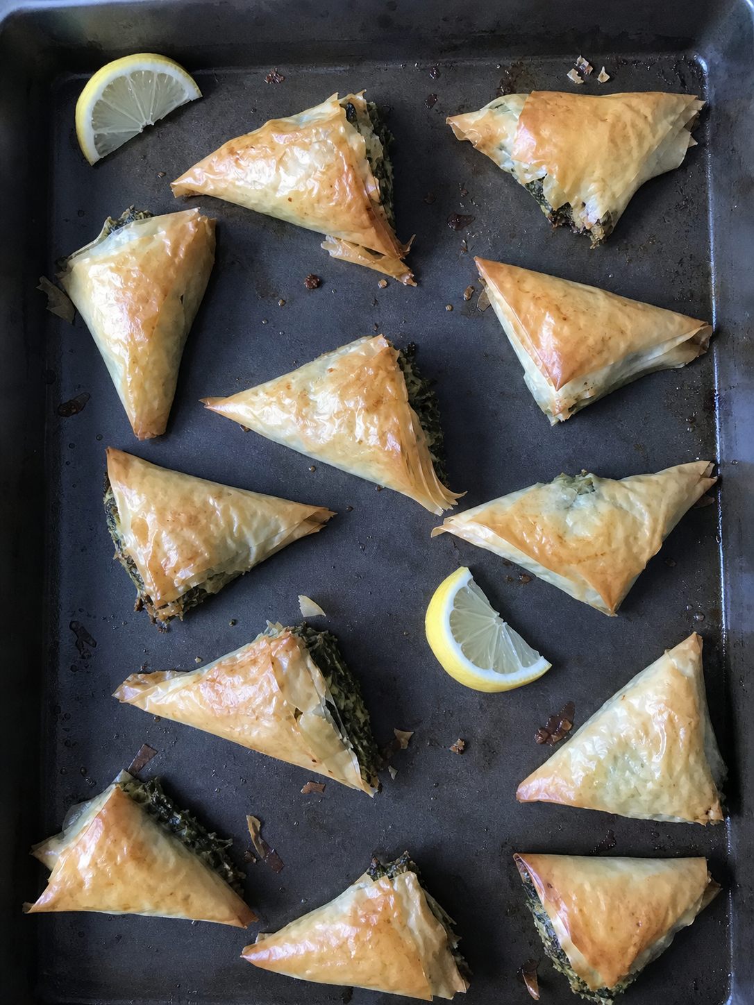 Small spinach feta filo pastries with lemon wedges