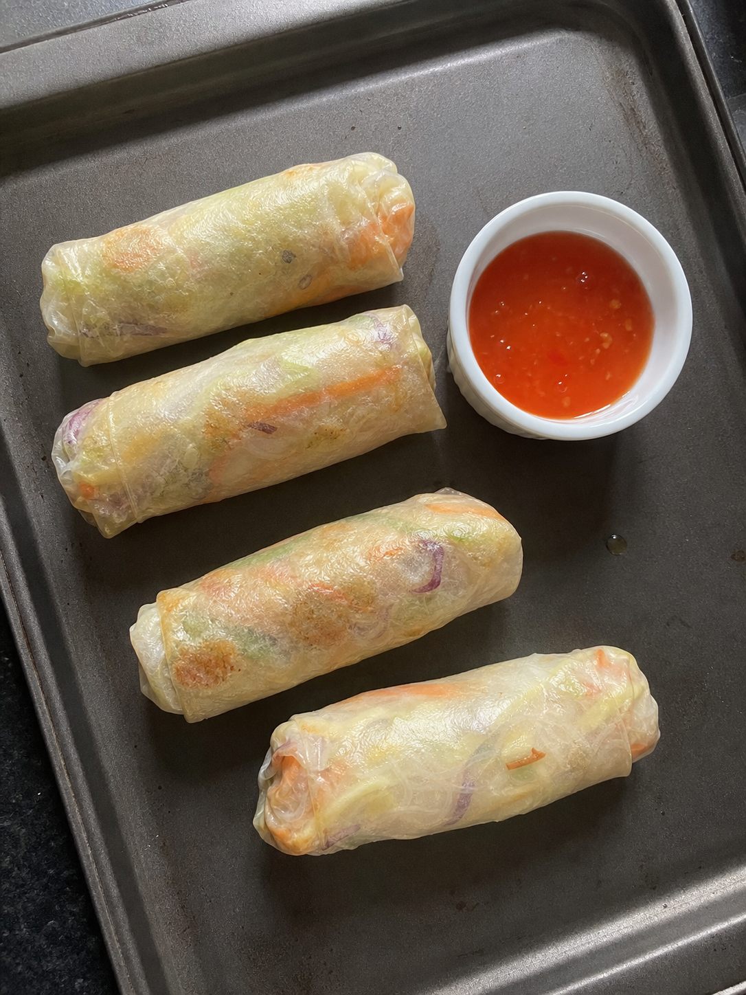 Crisp vegetable spring rolls with a small sweet chili dipping bowl