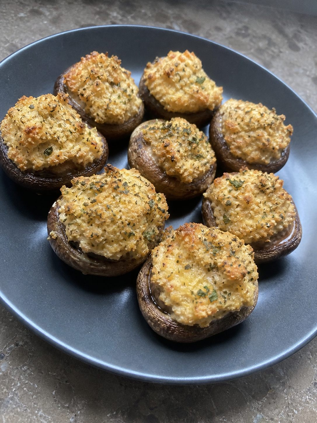 Small browned stuffed mushrooms with parsley on a plate
