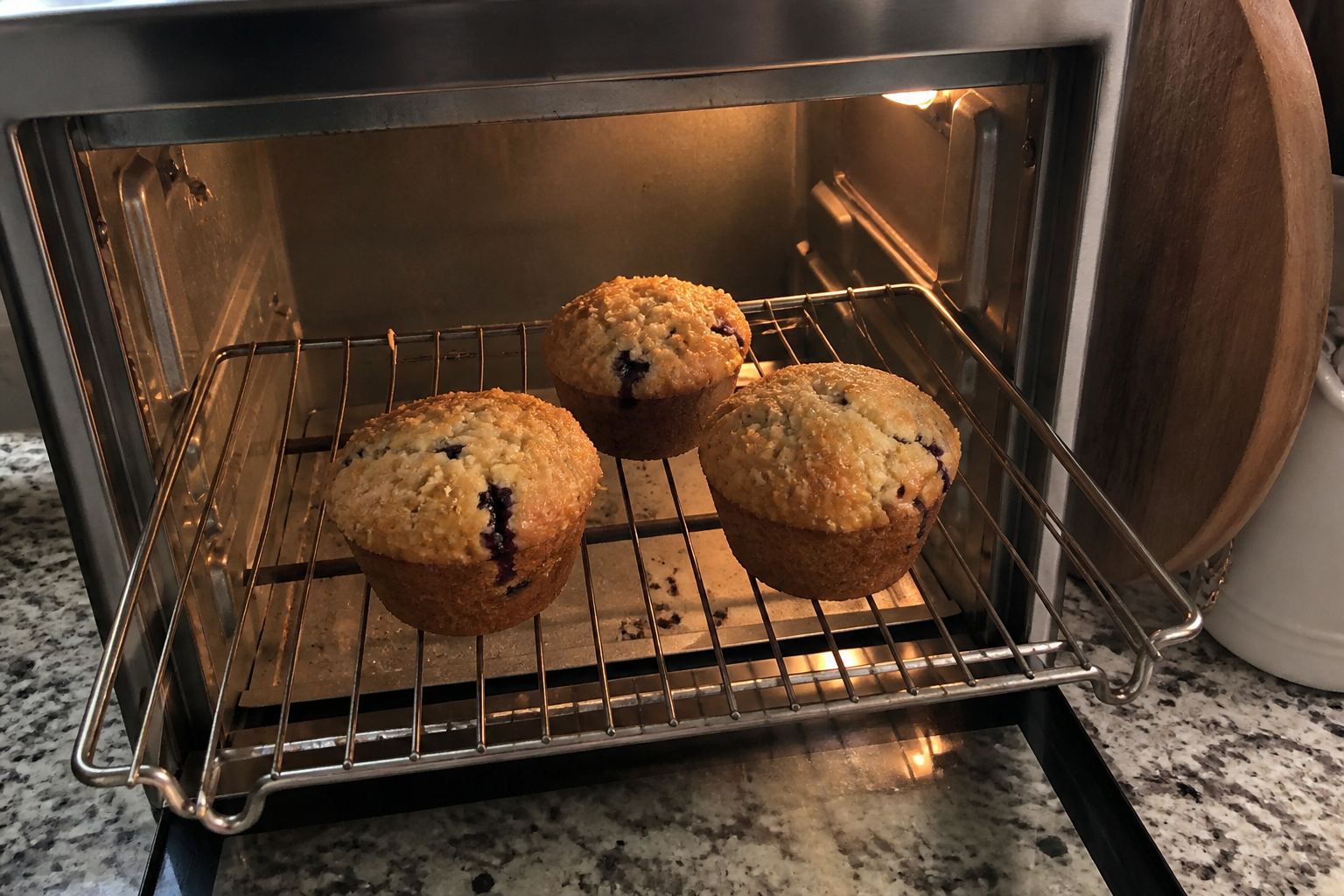 Muffins warming on a rack inside a toaster oven