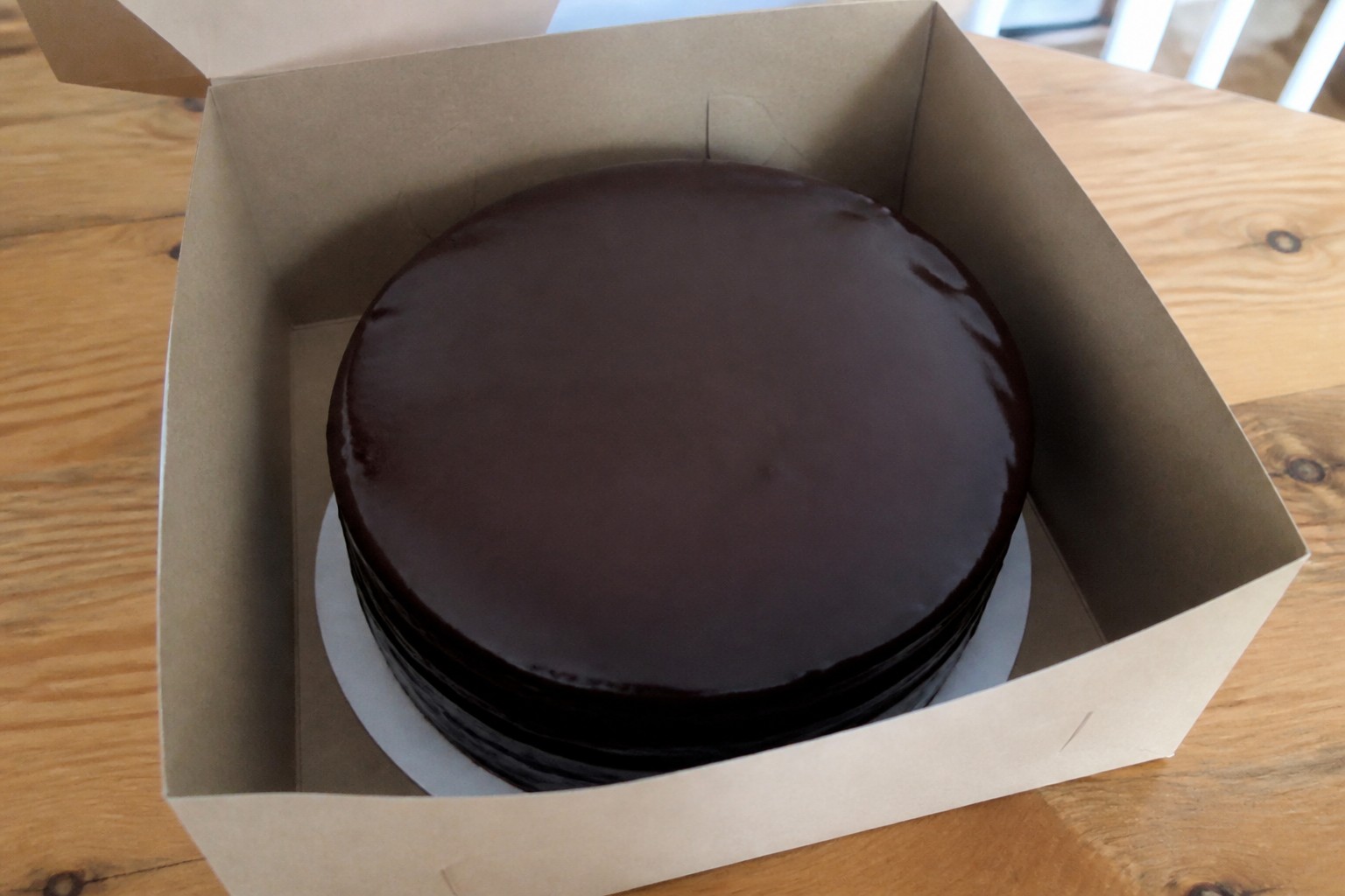 A close look at the finished storing homemade Sacher cake safely while protecting its glaze