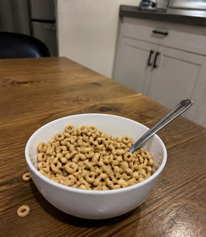 A simple bowl of golden cereal with milk on a wooden breakfast table