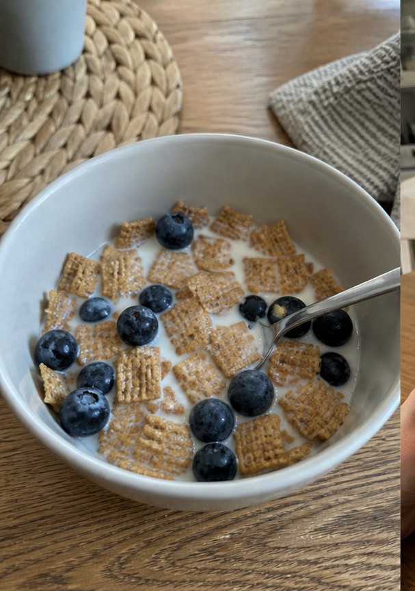 A simple bowl of golden cereal with milk on a wooden breakfast table