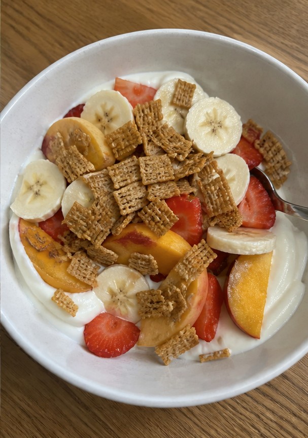 A homemade cereal snack mix with dried fruit and seeds on a parchment-lined tray