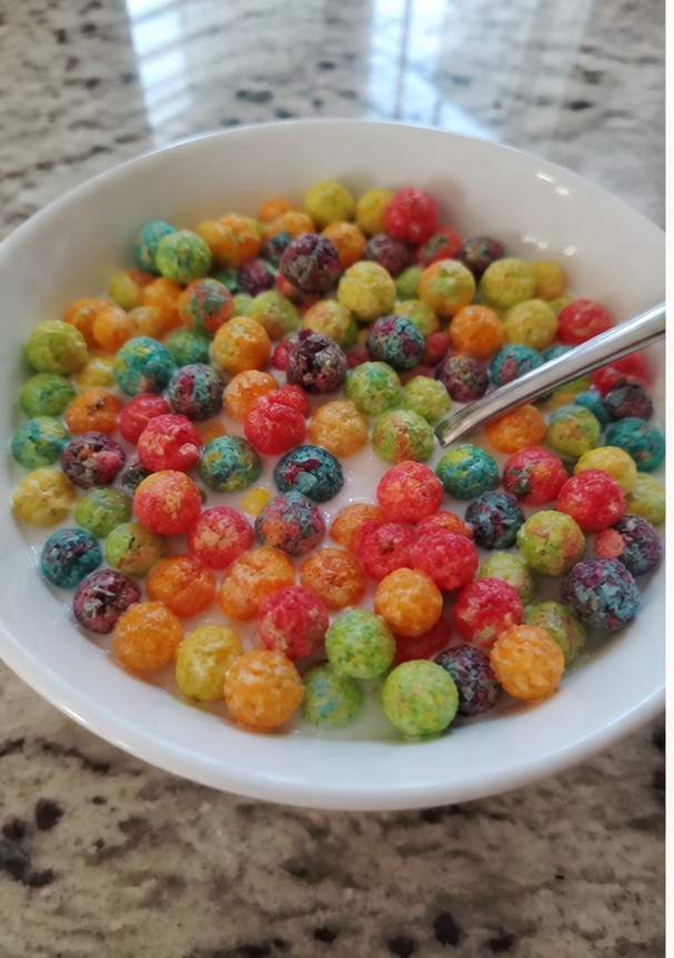A simple bowl of golden cereal with milk on a wooden breakfast table